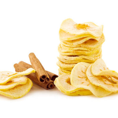 Dried apple rings and cinnamon sticks on white.