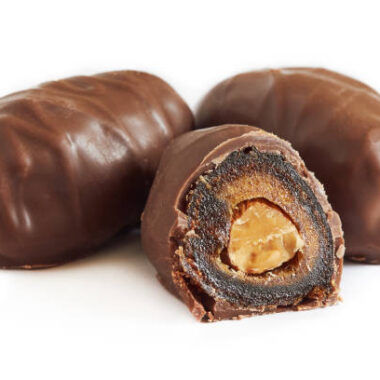 Chocolate covered dates stuffed with almonds isolated on white background
